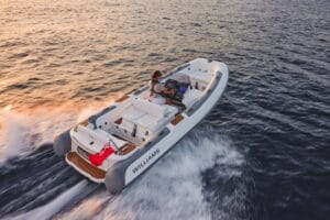 RIB tender boat speeding across the sea with just the helm driving it.