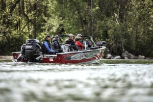 Aluminium fishing boat on the water with group of men on board