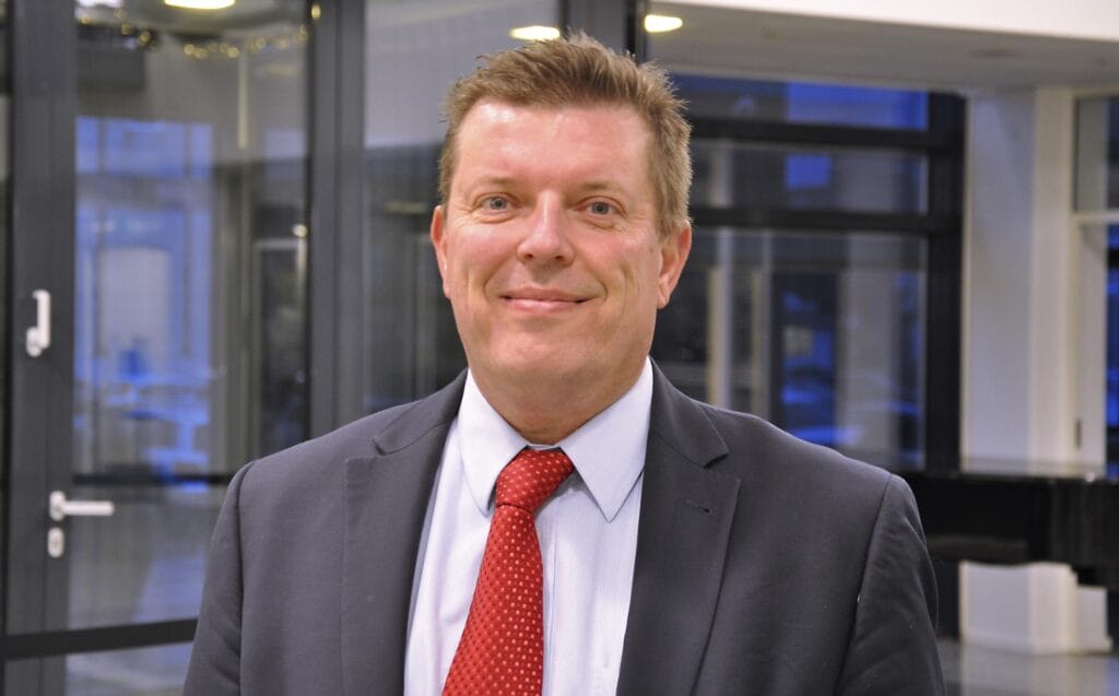 Headshot of smiling man wearing a suit and tie.