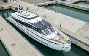 Side view of superyacht that has just been lowered in the water at shipyard.