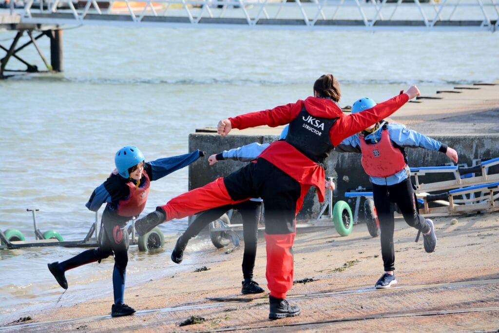 Group of children and an instructor having fun on the beach