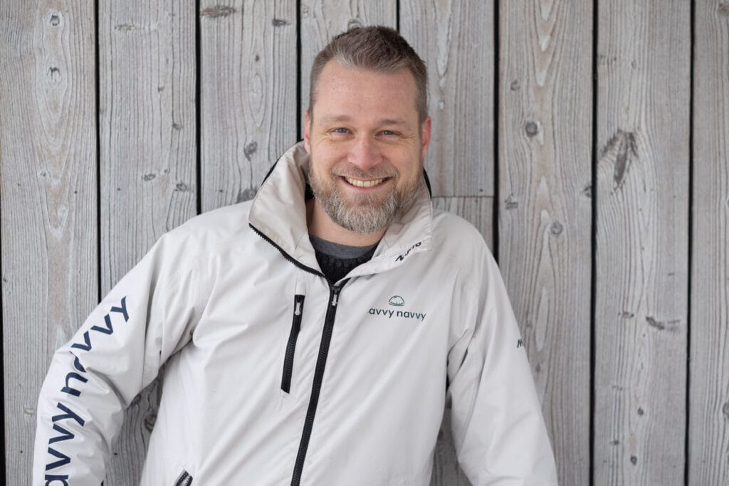 man with a beard in an off-white sailing jacket