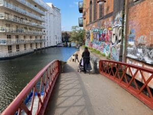 red brick coloured bridge with person crossing