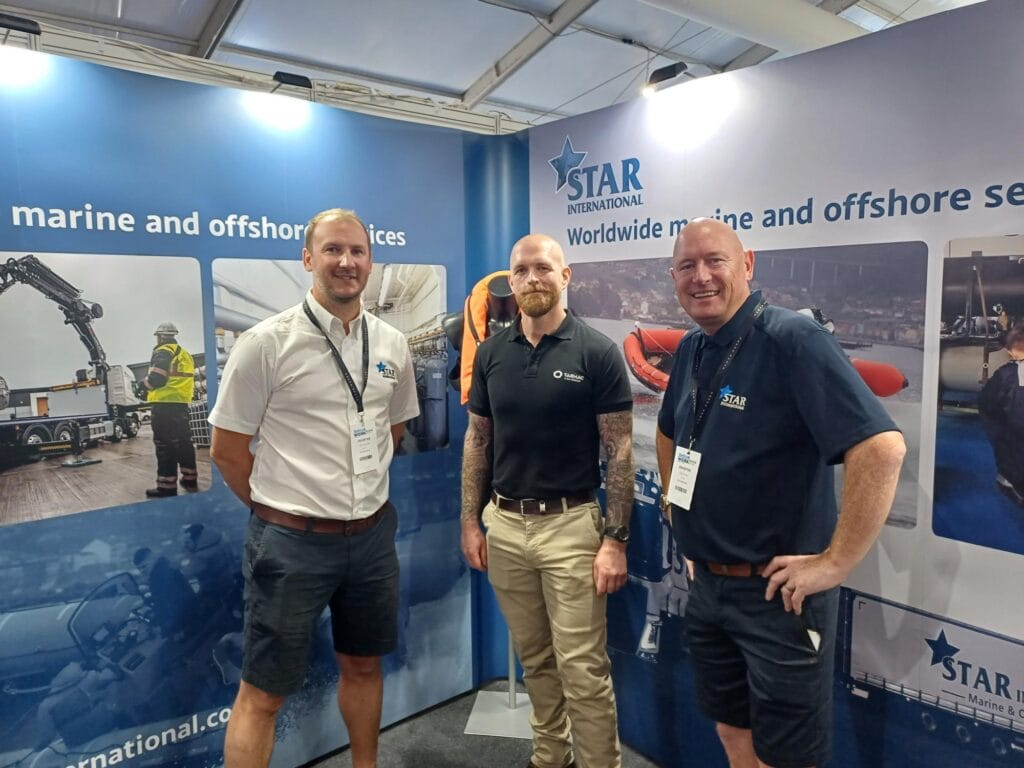 three men in front of an exhibition stand