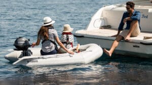 Small inflatable boat with Yamaha engine coming alongside a yacht