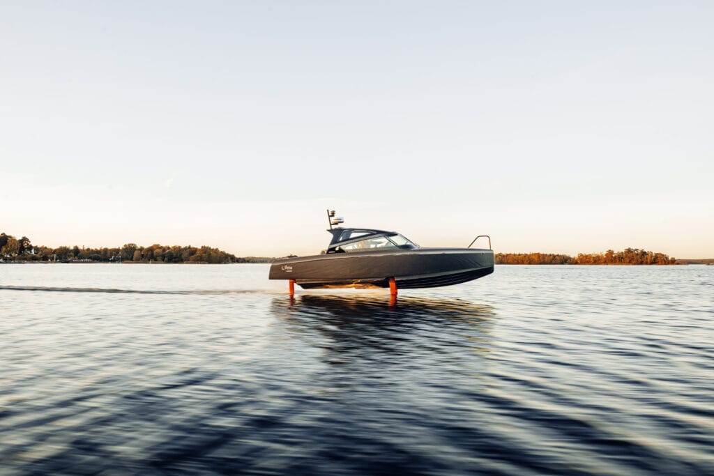 Grey hydro foiling boat flying across the water