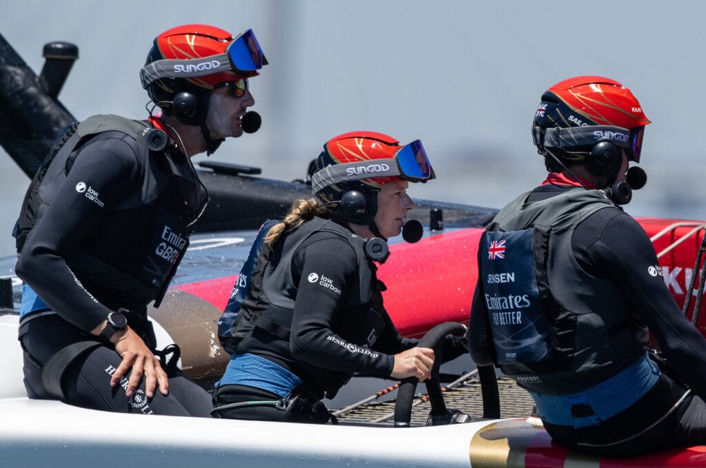 Hannah Mills, strategist of Emirates Great Britain SailGP Team, at the wheel alongside Giles Scott of Emirates Great Britain SailGP Team and Iain Jensen, wing trimmer of Emirates Great Britain SailGP Team, during a practice session ahead of the Oracle Los Angeles Sail Grand Prix at the Port of Los Angeles, in California, USA. 20th July 2023. Photo: Ricardo Pinto for SailGP. Handout image supplied by SailGP