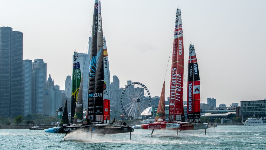 New Zealand SailGP Team helmed by Peter Burling, Emirates Great Britain SailGP Team helmed by Ben Ainslie and the fleet sail toward the Centennial Wheel and the Chicago skyline on Race Day 1 of the Rolex United States Sail Grand Prix | Chicago at Navy Pier, Season 4, in Chicago, Illinois, USA. 16th June 2023. Photo: Ricardo Pinto for SailGP. Handout image supplied by SailGP