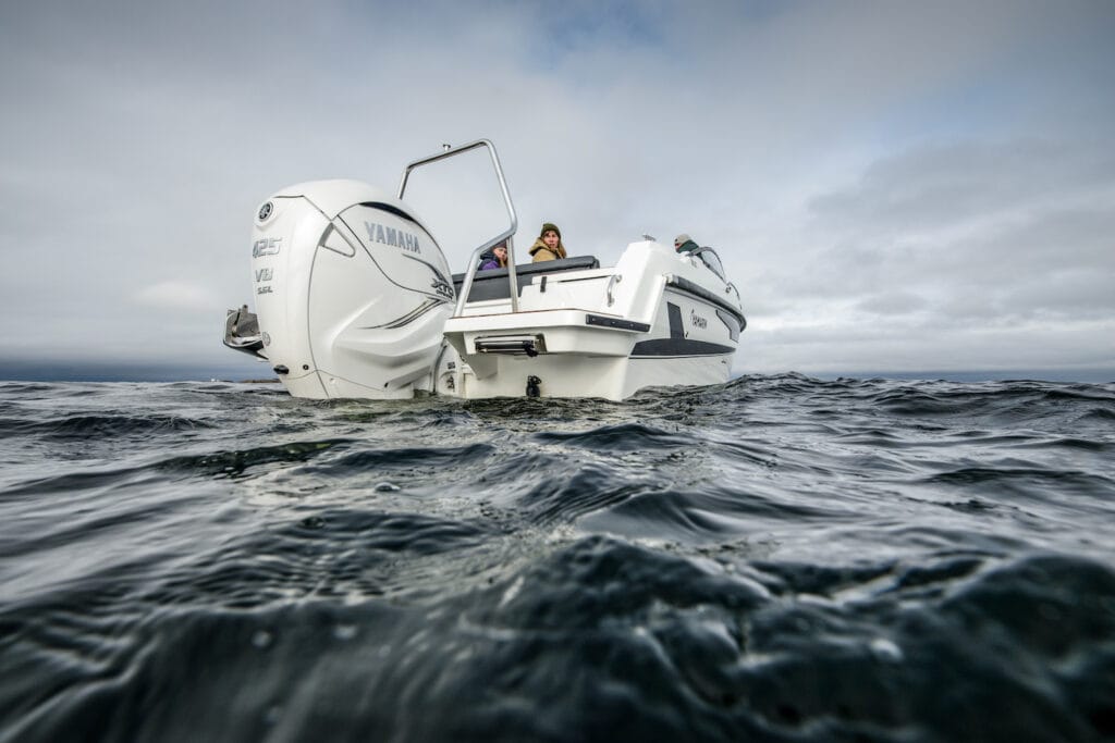 Water level view of a white boat with a large white outboard