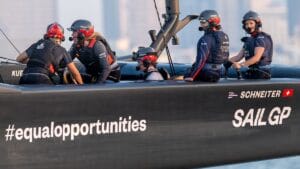 Group of four female sailors in SailGP boat.