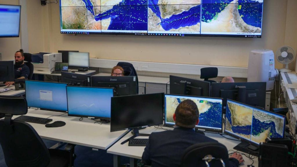 A room with computers and people and displays