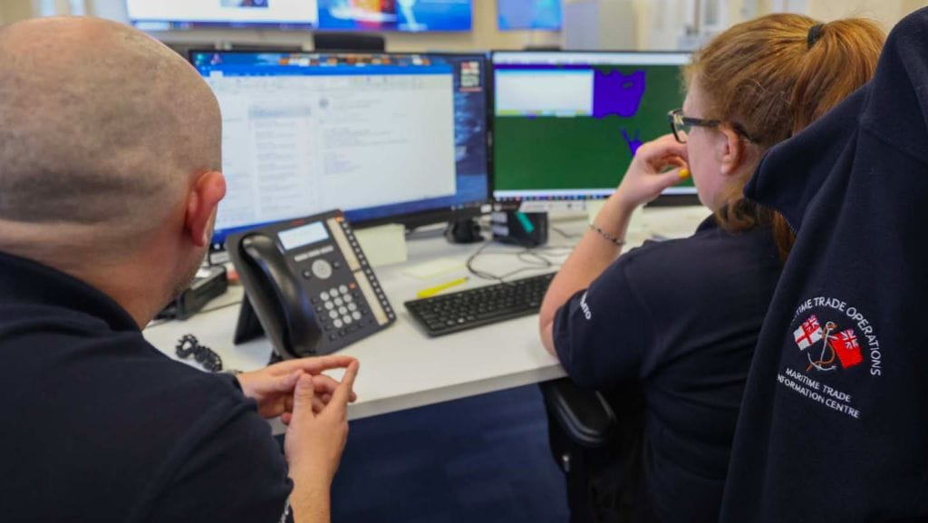 Two people concentrate on screen with SOS emails piling into inbox