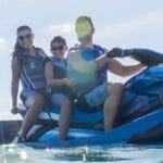 man, women and boy on back of a jetski