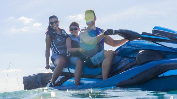 man, women and boy on back of a jetski