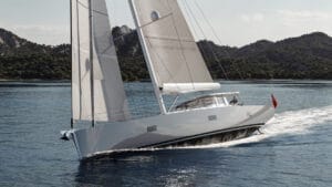 A sailboat on water with hills in background