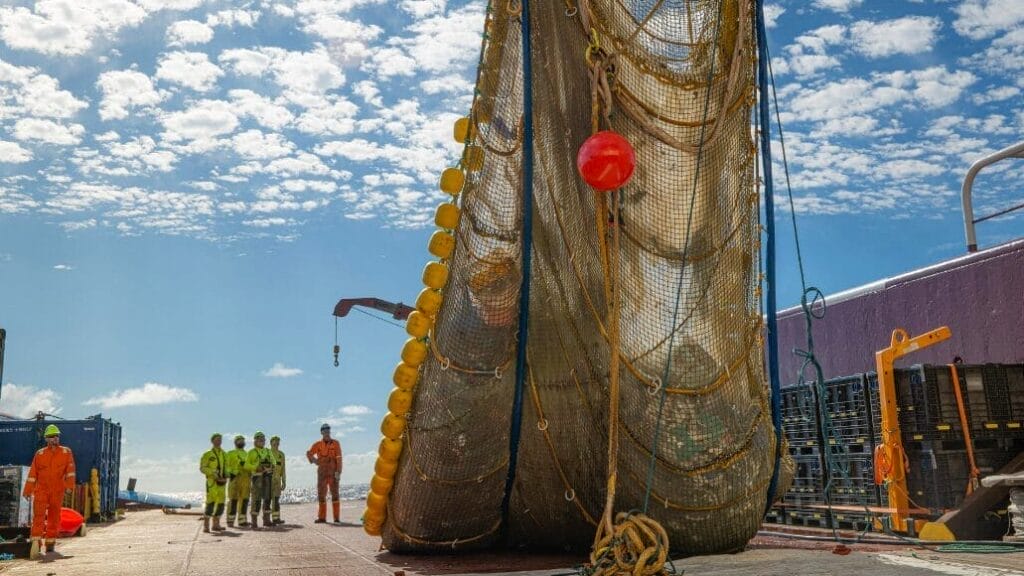 A net full of garbage being unloaded onto a boat