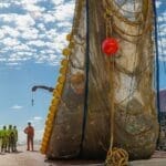 A net full of garbage being unloaded onto a boat