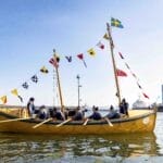 Yellow rowing boat with flags, on a calm sea
