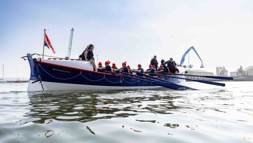 People rowing a boat on calm water