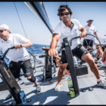 crew of sailors on deck in marine clothing working together in branded team wear