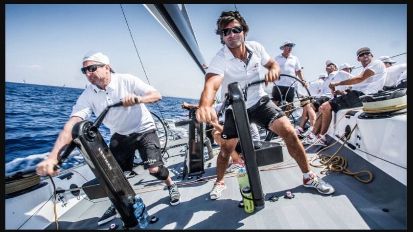 crew of sailors on deck in marine clothing working together in branded team wear