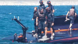 sailors from after demasting stand around on AC75