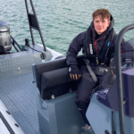 boy sits on boat that he's using to circumnavigate UK and Northern Ireland in eRIB challenge