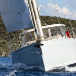 Mishi 88 yacht bow surges through water powered by sail