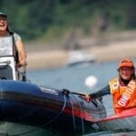 two girls on the water. One helming a RIB boat, one in a dinghy