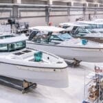 boatbuilding factory with row of white powerboats in production