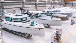 boatbuilding factory with row of white powerboats in production