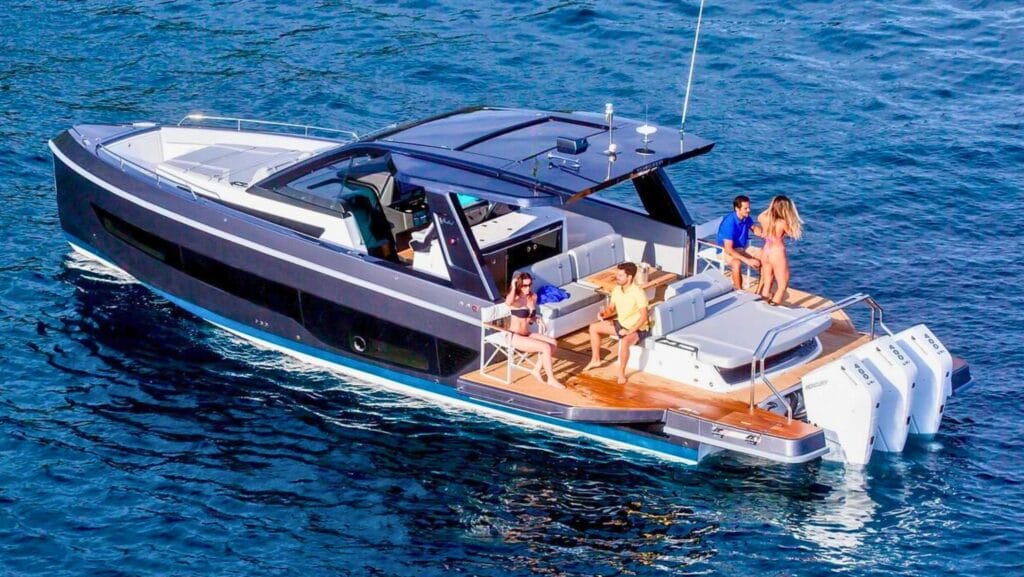 sleek black daycruiser boat with people sunbathing aft