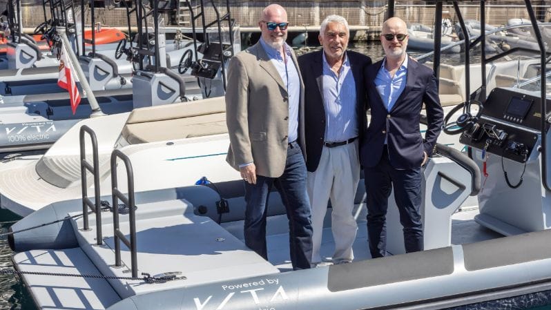 Three men stand on a boat, They're from Evoy and Vita and are now working together