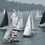 A fleet of yachts, sails full, on the water at the start of the Ostar race . . .a similar fleet to the new Worldstar race?
