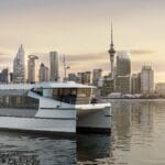 Electric ferry on the water with Auckland cityscape as a backdrop