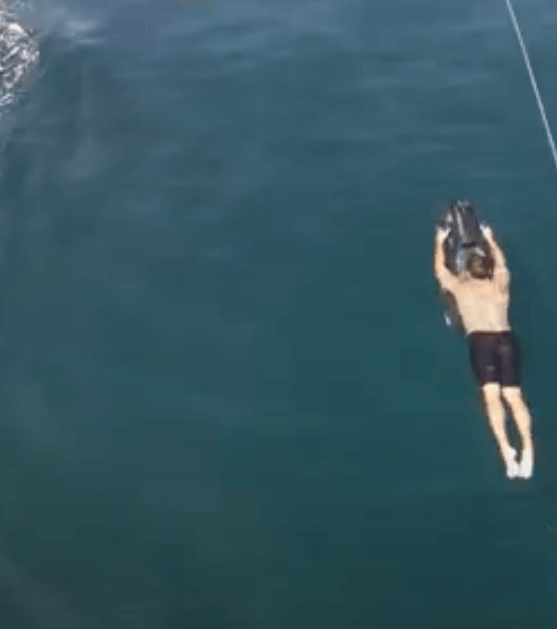 aerial view of man being dragged along underwater by sea scooter from iAqua