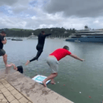 four people jumping off harbour wall in Dartmouth