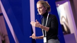 woman in black polo neck speaking at conference