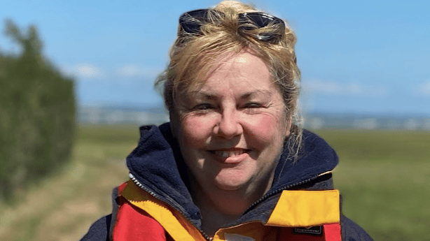 Rachel Perrin looks at camera wearing lifejacket. She went overboard near Isle of Wight but was rescued three hours later