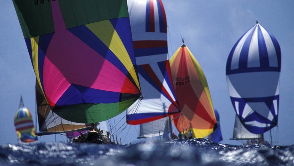 Vivid colours on spinnakers as yachts race in Solent. First Class Sailing offers spinnaker sailing courses on boats like these