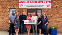 A gorup of people holding a banner stand under another banner. The first is Polymarine, the second is Anglo Adhesives.