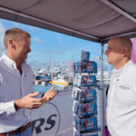 Two men in white shirts talk to each other