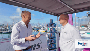 Two men in white shirts talk to each other