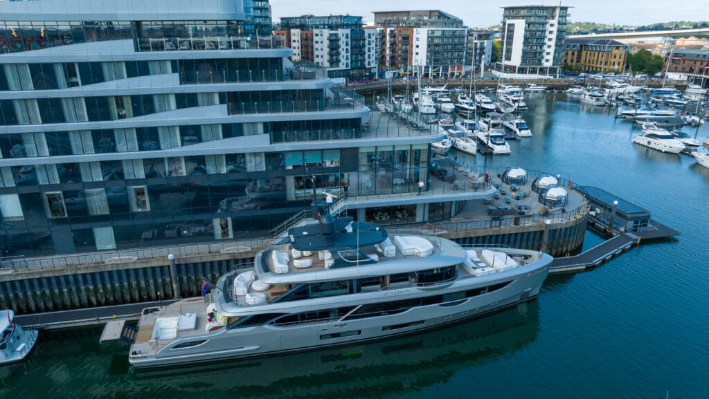 Aerial view of superyacht on quay with Ocean Village marina in background