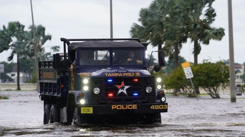 Police vehicle in water on road in Tampa as Hurricane Helene threatens to cancel IBEX