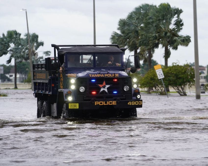 Police vehicle in water on road in Tampa as Hurricane Helene threatens to cancel IBEX