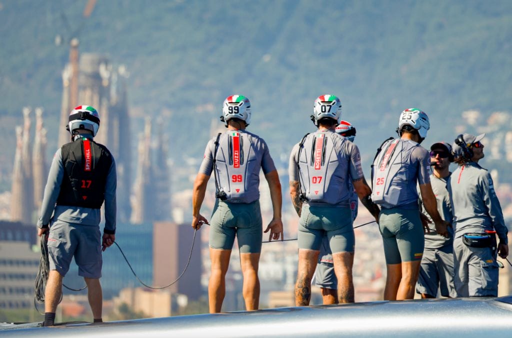 Rear view of the Luna Rossa Prada Pirelli team, in grey shorts and helmets