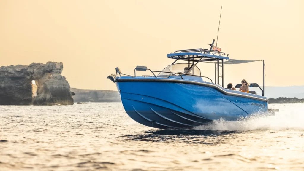 blue hulled motor boat on passage in sunset light