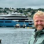 Adam Greene in front of a superyacht