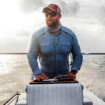 man on boat with baseball cap on and shades